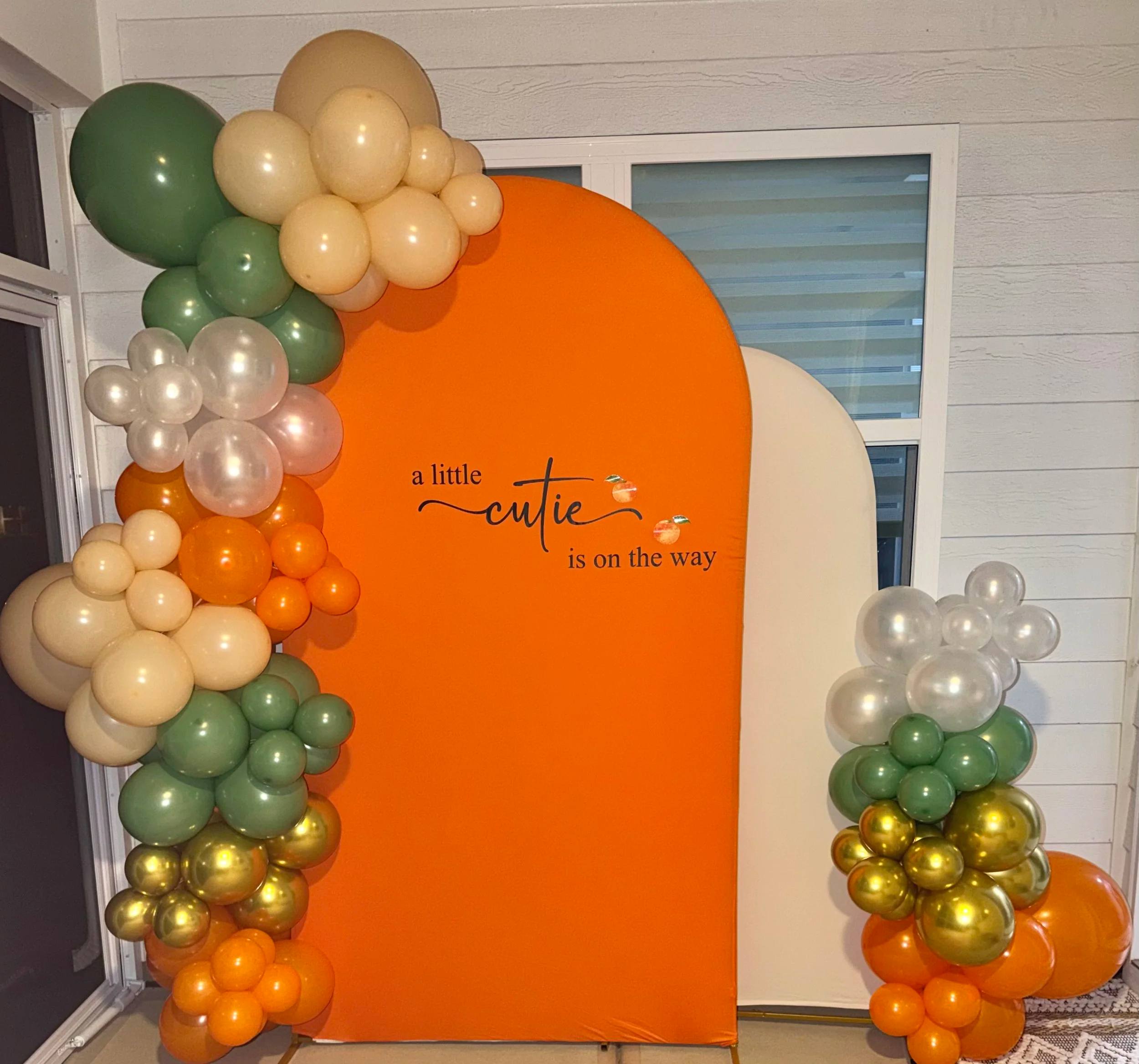 Orange and sage backdrop reading A Little Cutie Is On The Way