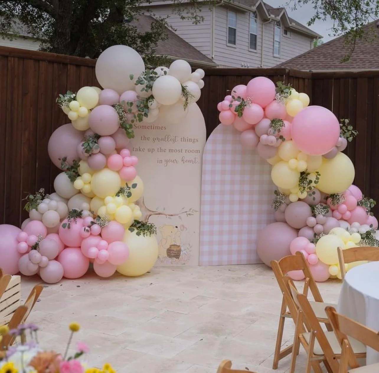 Pastel balloon garland draped over two arched backdrops