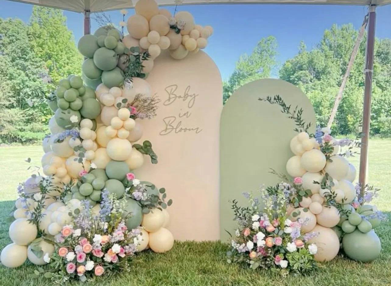 Sage and cream balloon backdrop outdoors with florals
